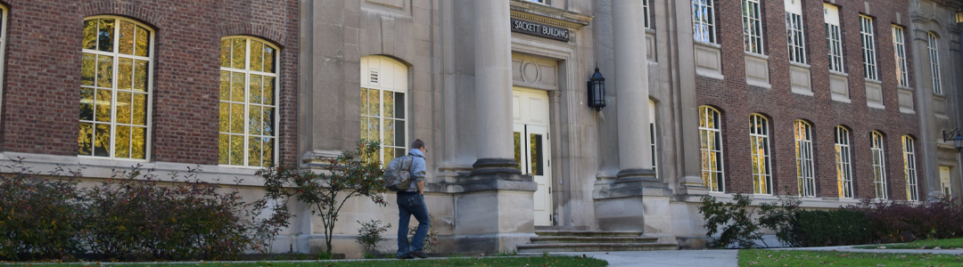 person walking in front of stone building