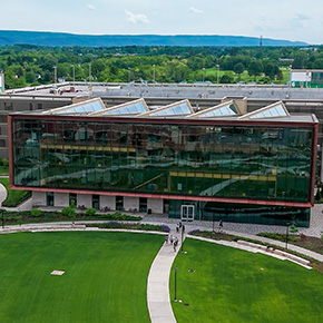 a building made mostly of glass and a green lawn